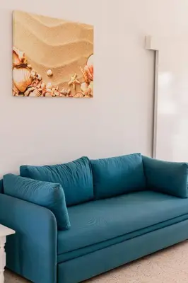 a blue couch in a room with a painting on the wall at Flokkas Hotel Apartments in Protaras