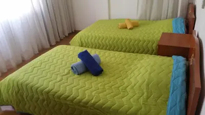 two twin beds in a bedroom with green sheets at Gulf Palace Apartments in Limassol