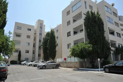 a parking lot with cars parked in front of a building at Gulf Palace Apartments in Limassol