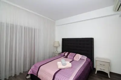 a bedroom with a bed with a purple blanket at Gulf Palace Apartments in Limassol