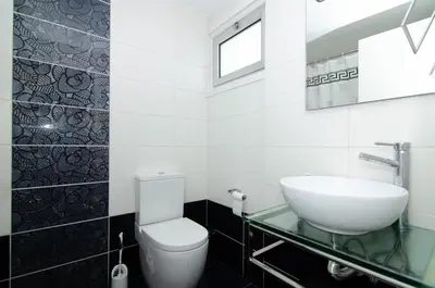 a bathroom with a white toilet and a sink at Gulf Palace Apartments in Limassol
