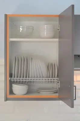 a cupboard with plates and bowls in it at Helios Mackenzie One Bedroom Flat in Larnaka