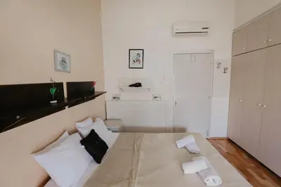 a small white bedroom with a bed with two pillows at Pirgos beach house in Larnaka