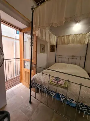 a bedroom with a canopy bed with a balcony at Christiana's stone studios in Pano Lefkara