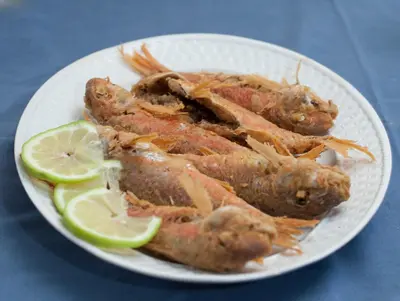 a plate of food with lobsters and lime slices at Tylos Beach Hotel in Kato Pyrgos