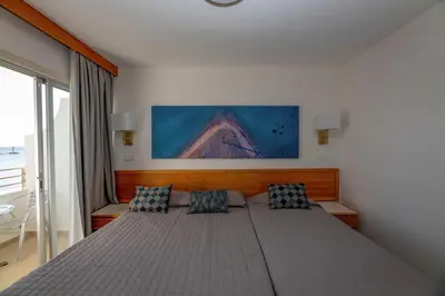 a bedroom with a large bed with two pillows at Tylos Beach Hotel in Kato Pyrgos