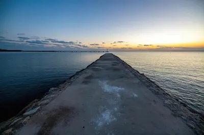a pier in the middle of a large body of water at Tylos Beach Hotel in Kato Pyrgos