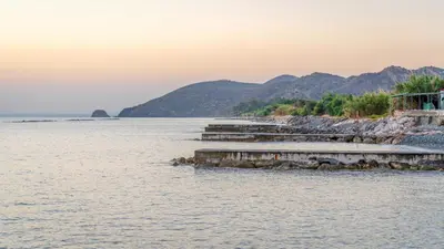 a view of a body of water with mountains in the background at Tylos Beach Hotel in Kato Pyrgos