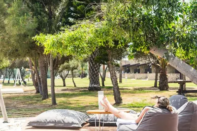 a woman laying on a couch in a park at Elya Beach Luxury Suites in Ayios Theodhoros