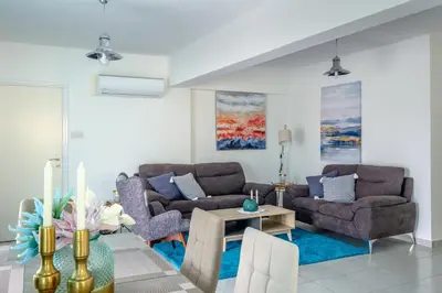 a living room with two couches and a table at The Coral Penthouse in Larnaka
