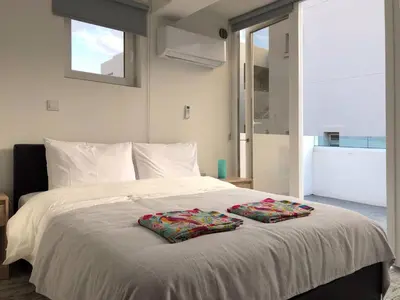 a bedroom with a bed with two pillows on it at Ayia Napa GO SEA Sunny Apt with Terrace 5 min to Beach in Ayia Napa