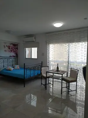 a bedroom with a bed and a table and chairs at Stelia's Seagate Studio Apt. in Larnaka