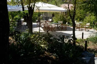 a patio with tables and chairs under an umbrella at Jubilee Hotel Troodos in Troodos