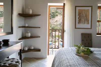 a bedroom with a bed and a door to a balcony at Casale Panayiotis in Kalopanayiotis