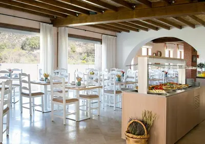 a restaurant with white chairs and tables and a buffet at Casale Panayiotis in Kalopanayiotis