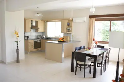 a kitchen and dining room with a table and chairs at Holidays Villas in Pissouri