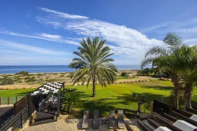 a view of the beach from the balcony of a house at Protaras El Greco Seafront Villa, Greco Mare in Protaras