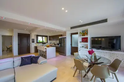 a living room with a couch and a table with chairs at Protaras El Greco Seafront Villa, Greco Mare in Protaras