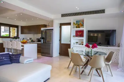 a living room and kitchen with a table and a couch at Protaras El Greco Seafront Villa, Greco Mare in Protaras