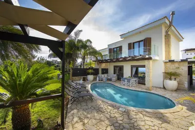 a villa with a swimming pool and a house at Protaras El Greco Seafront Villa, Greco Mare in Protaras