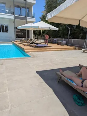 a couple of people laying on chaises next to a pool at Kapparis Apartment Mythical Sands in Protaras