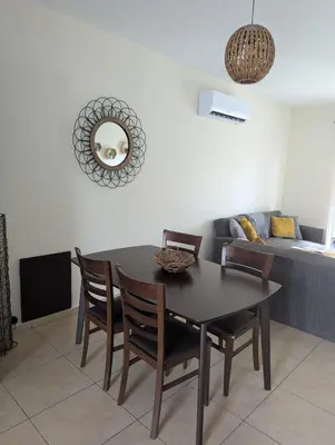 a dining room with a table and chairs and a couch at Kapparis Apartment Mythical Sands in Protaras