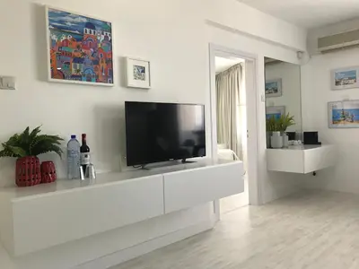 a living room with a tv on a white cabinet at Sea View Holiday Apartment in Larnaka