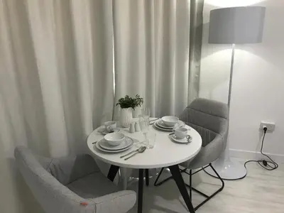 a white table with two chairs and a table with plates and cups at Sea View Holiday Apartment in Larnaka