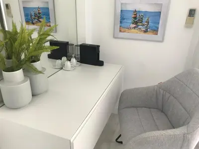 a living room with a chair and a white desk at Sea View Holiday Apartment in Larnaka