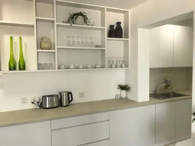 a white kitchen with white cabinets and a sink at Sea View Holiday Apartment in Larnaka