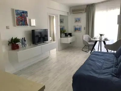 a living room with a couch and a tv and a table at Sea View Holiday Apartment in Larnaka