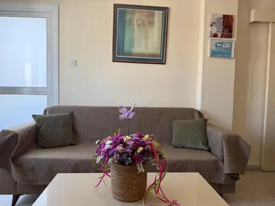 a living room with a couch and a vase of flowers at Terpsithea Apartments in Ayia Napa