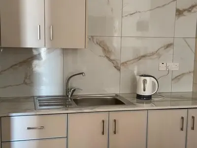 a kitchen with a sink and white cabinets at Terpsithea Apartments in Ayia Napa