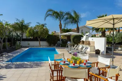 a patio with a table and chairs next to a pool at Larnaca Villa Anthea 12 in Larnaka