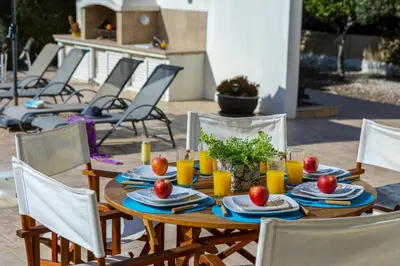 a wooden table with plates of food and orange juice at Larnaca Villa Anthea 12 in Larnaka