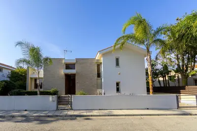 a white house with palm trees in front of it at Larnaca Villa Anthea 12 in Larnaka