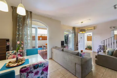 a living room with a couch and a table at Protaras Villa Rocco in Paralimni