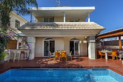 a house with a swimming pool in front of a house at Protaras Villa Rocco in Paralimni