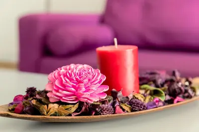 a candle sitting on a plate with a pink flower at Savvas City Centre Flat in Larnaka