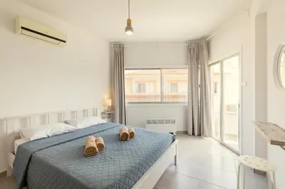 a bedroom with a bed with two pairs of shoes on it at Savvas City Centre Flat in Larnaka