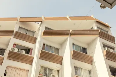 a tall white building with wooden balconies on it at Savvas City Centre Flat in Larnaka