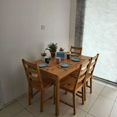 a wooden dining room table with four chairs and a table and chairsuggest at Merab Holidays Apartments FA213 in Ayia Napa