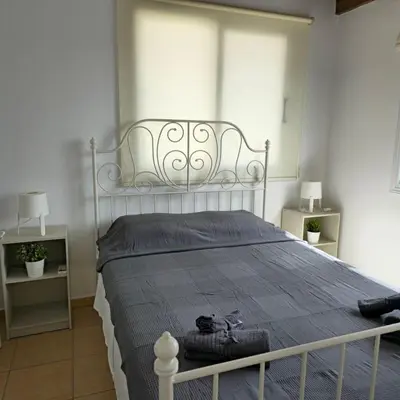 a bedroom with a white bed with a blue blanket at Merab Holidays Apartments FA213 in Ayia Napa
