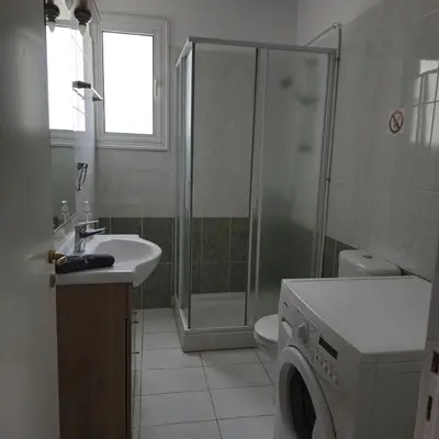 a bathroom with a shower sink and a washing machine at Merab Holidays Apartments FA213 in Ayia Napa