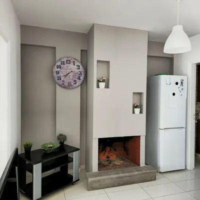 a living room with a fireplace and a clock on the wall at Merab Holidays Apartments FA213 in Ayia Napa