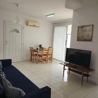 a living room with a couch and a tv and a table at Merab Holidays Apartments FA213 in Ayia Napa