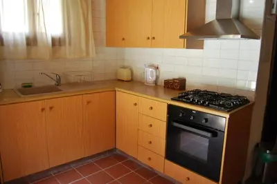a kitchen with wooden cabinets and a stove top oven at Xenis House in Galata