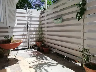 a privacy fence with potted plants on it at Sparrows Nest in Larnaka