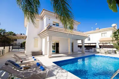 a villa with a swimming pool in front of a house at Villa Malama in Paralimni