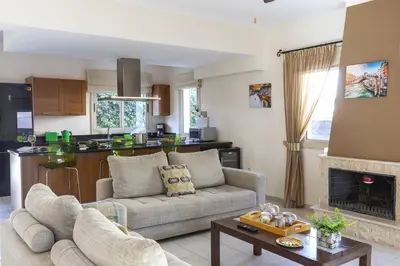 a living room with a couch and a kitchen at Villa Malama in Paralimni